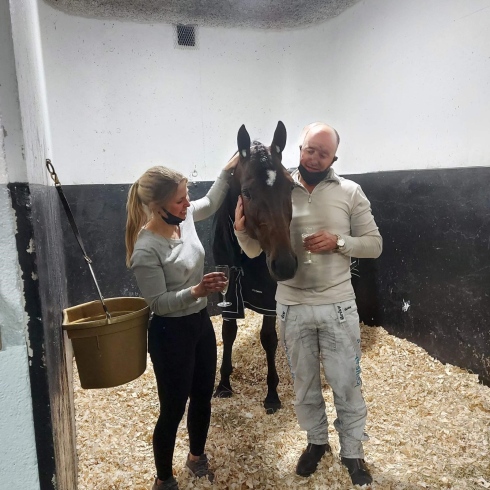 Power firar segern i stallet efter loppet tillsammans med sin skötare My Hedberg och tränare/kusk Robert Bergh. Foto av Privat